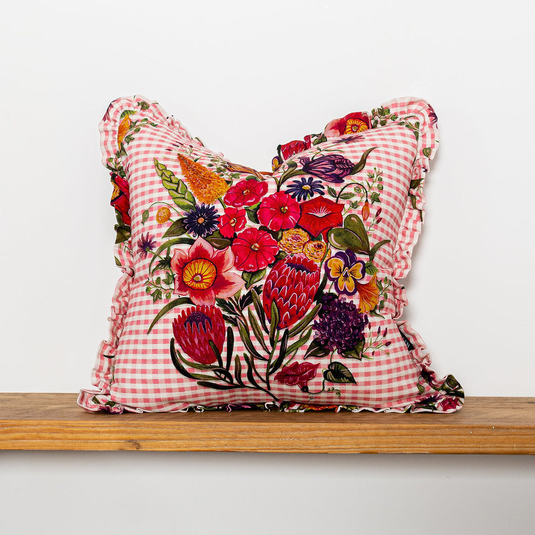 Wear-the-walls-linen-frilled-cushion-in-posy-cheery-gingham-frilled-cushion-large-floral-secondary-print-bold-print-hand-illustrated-lonen-cotton-mix-frill-detail-edges-made-in-england 