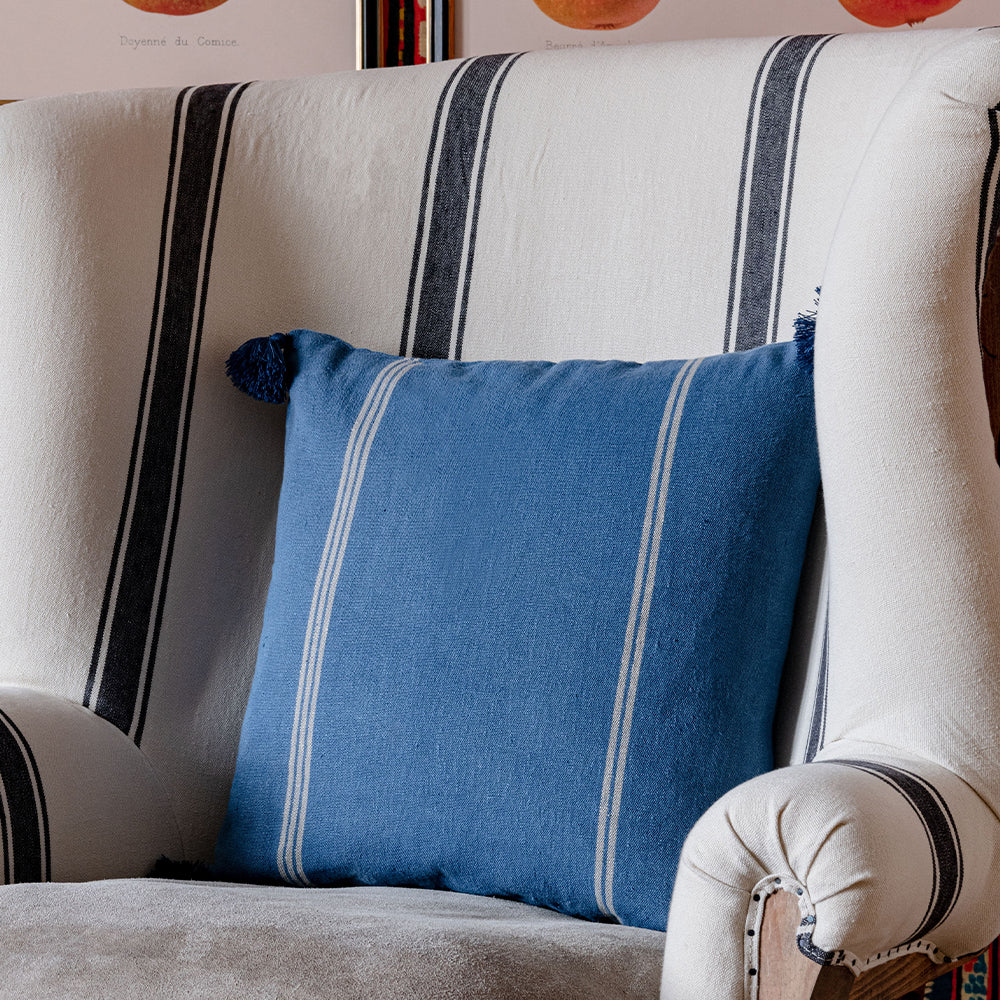 Katalin-stripe-linen-cushion-blue-white-mind-the-gap-with-tassels-black-and-white-armchair